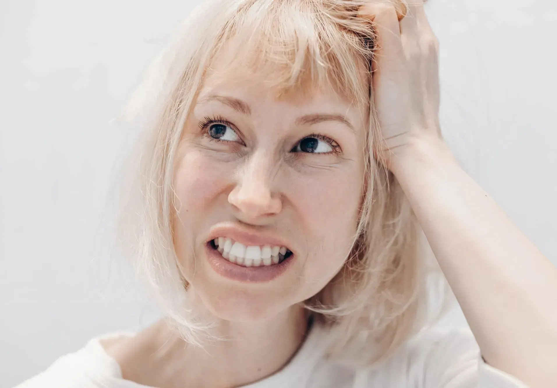 Patient inspecting worn teeth in mirror at East Ellijay Family and Cosmetic Dentistry