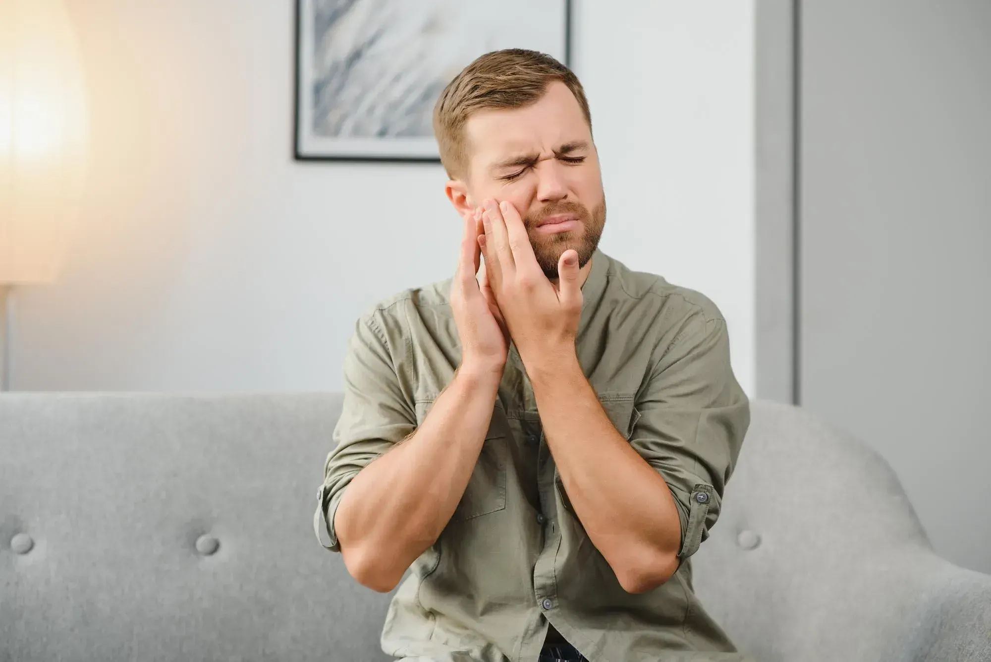 Patient holding cheek from tooth pain at East Ellijay Family & Cosmetic Dentistry